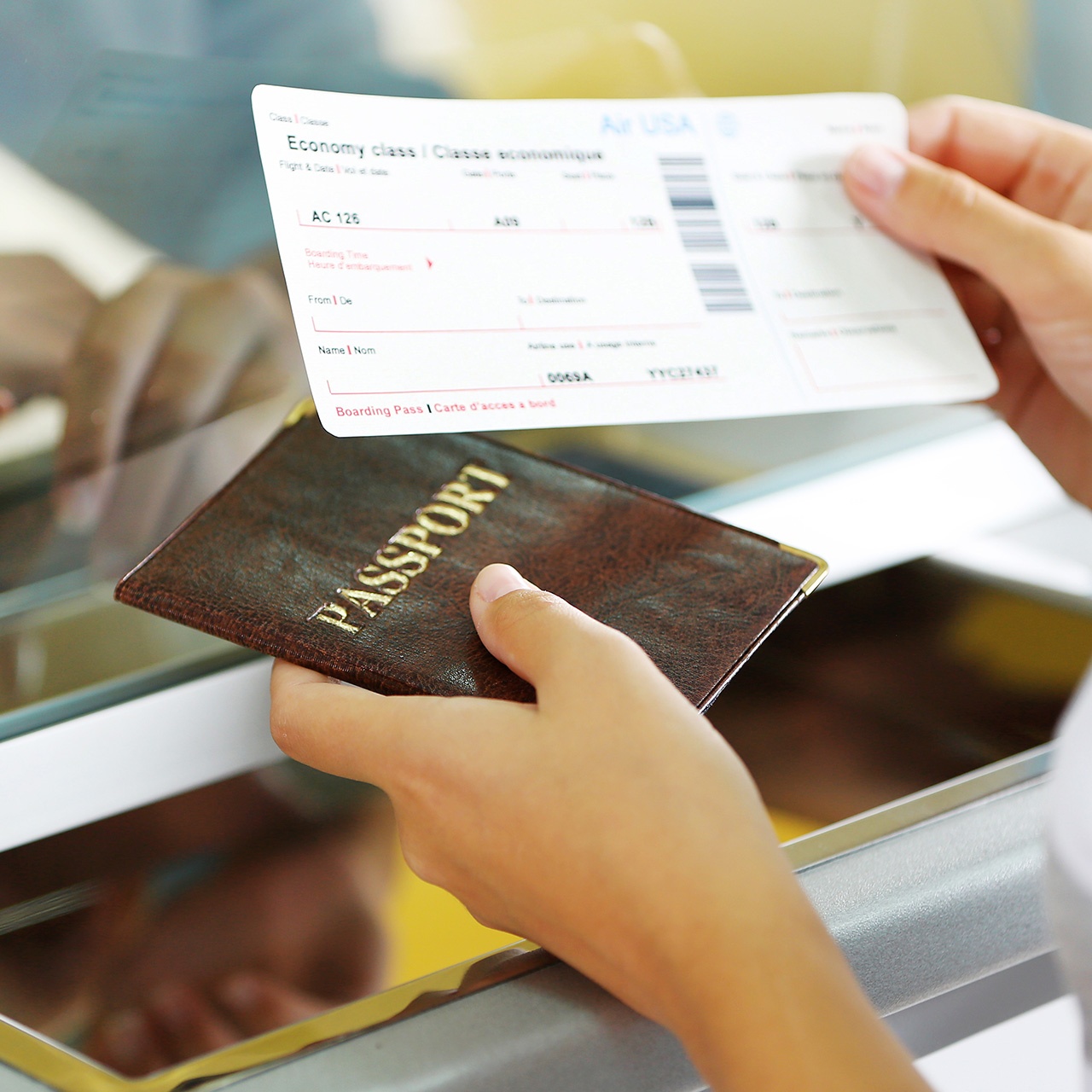 One person is holding a flight ticket and a passport.